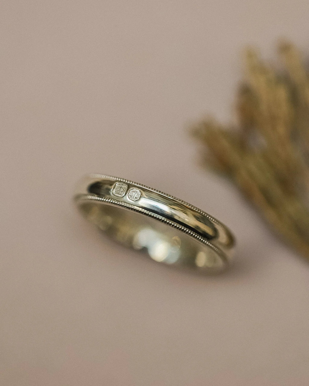 Close-up of 4mm white gold wedding band with visible hallmarks