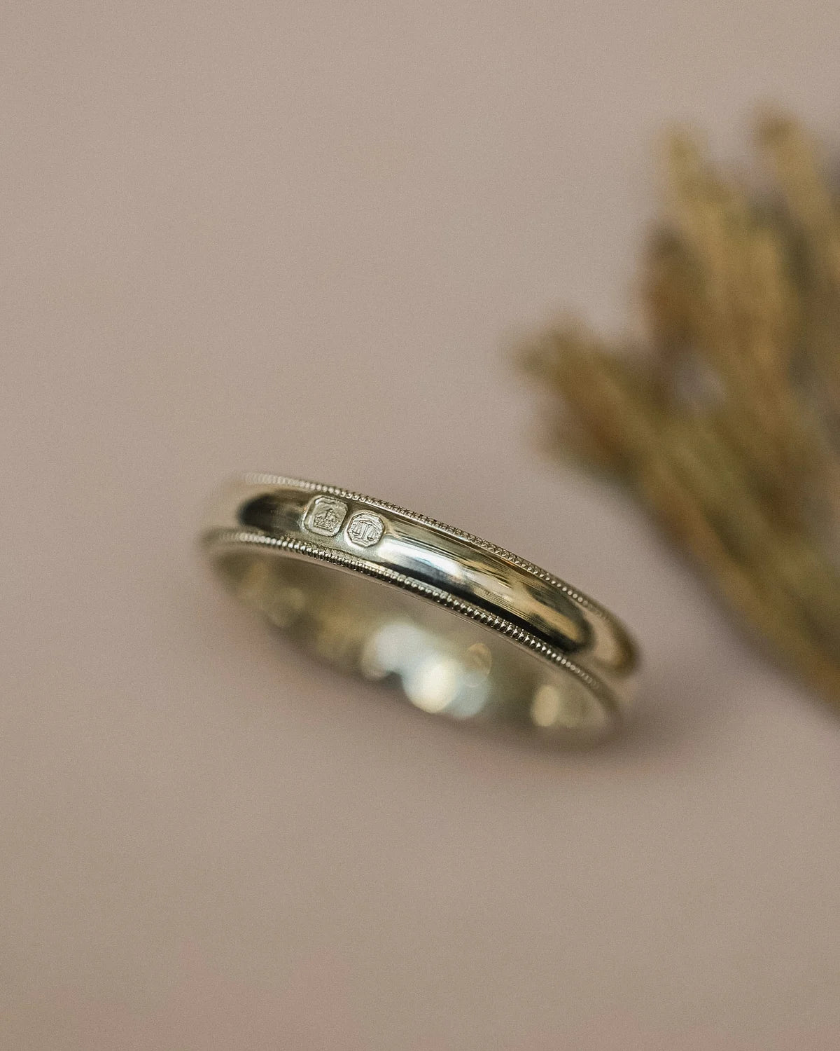 Close-up of 4mm white gold wedding band with visible hallmarks