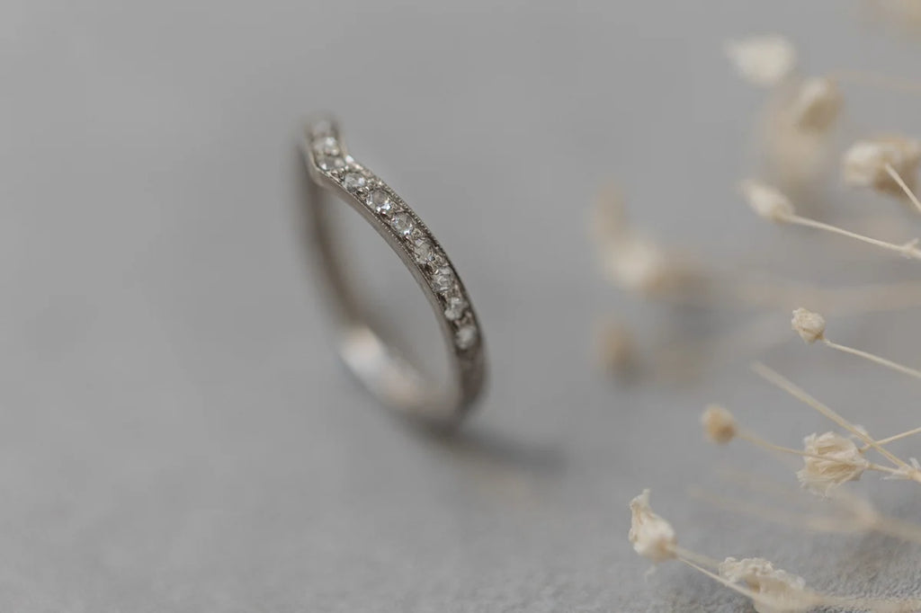 Silver ring with small diamonds on a gray background