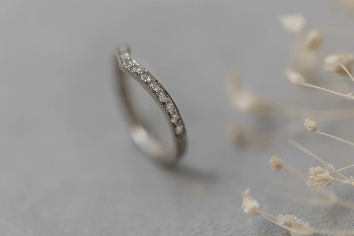 Silver ring with small diamonds on a gray background