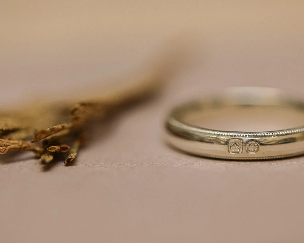 Side view of court shaped wedding ring with hand engraved milled edge