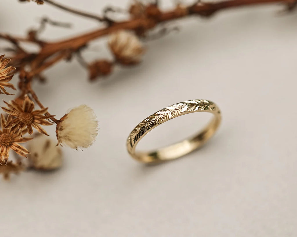 Close-up of 18ct yellow gold laurel leaf engraved ring