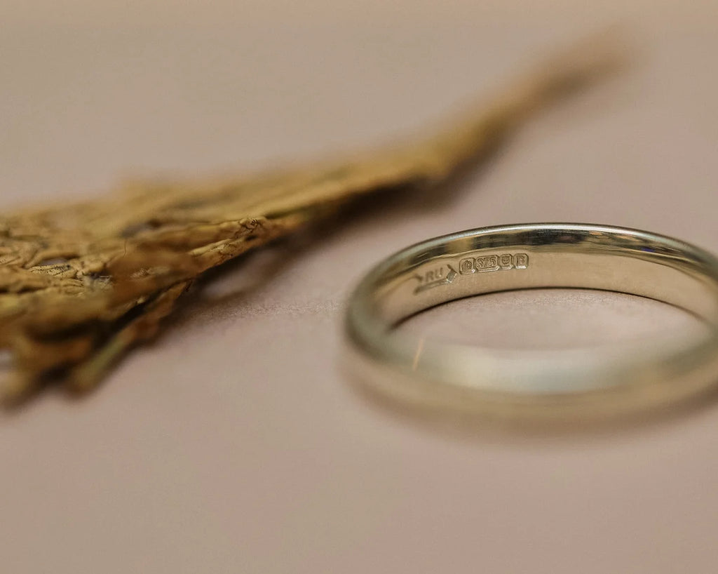 Angled view of 9ct white gold milled edge wedding ring