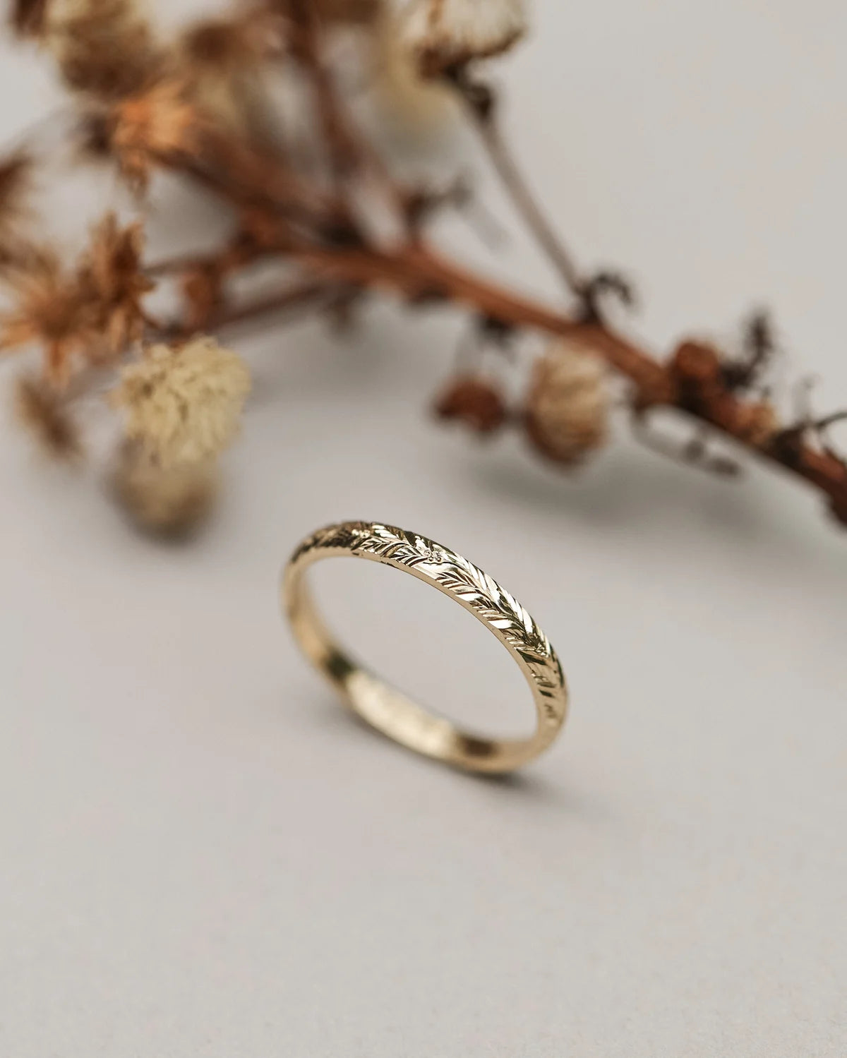 Angled view of 18ct yellow gold laurel leaf engraved wedding ring