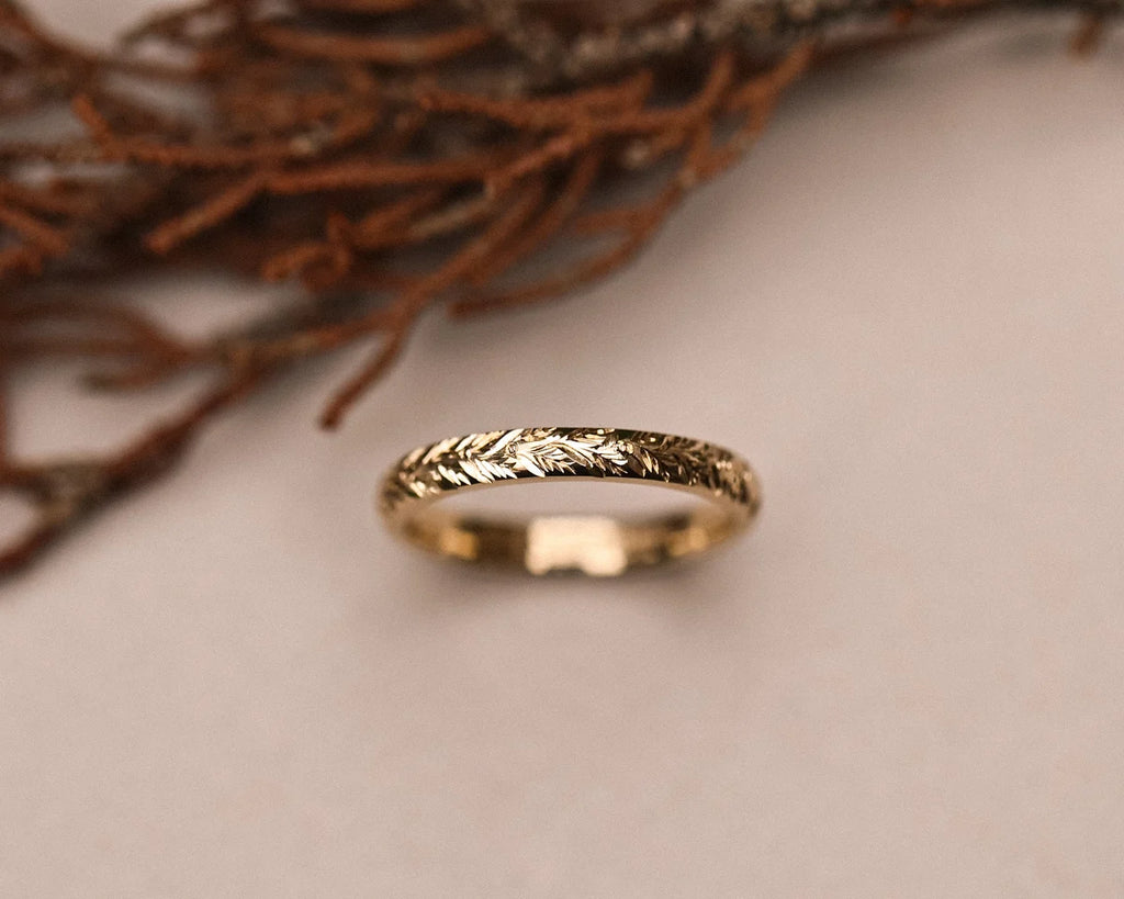 Close-up of 9ct yellow gold laurel leaf engraved wedding ring