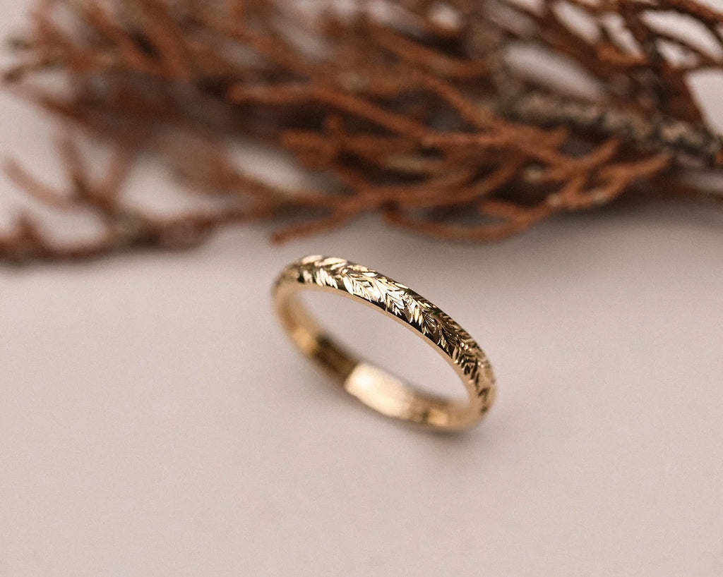 Angled view of 3mm laurel leaf wedding ring in yellow gold