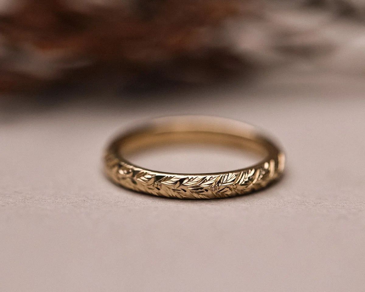 Detailed view of laurel leaf engraving on yellow gold band
