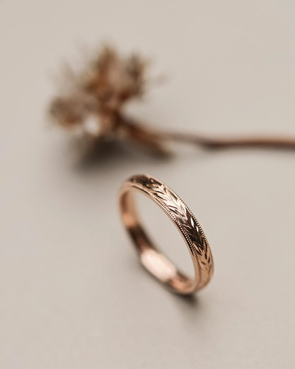 Side view of 18ct rose gold ring with hand engraved olive leaf motif