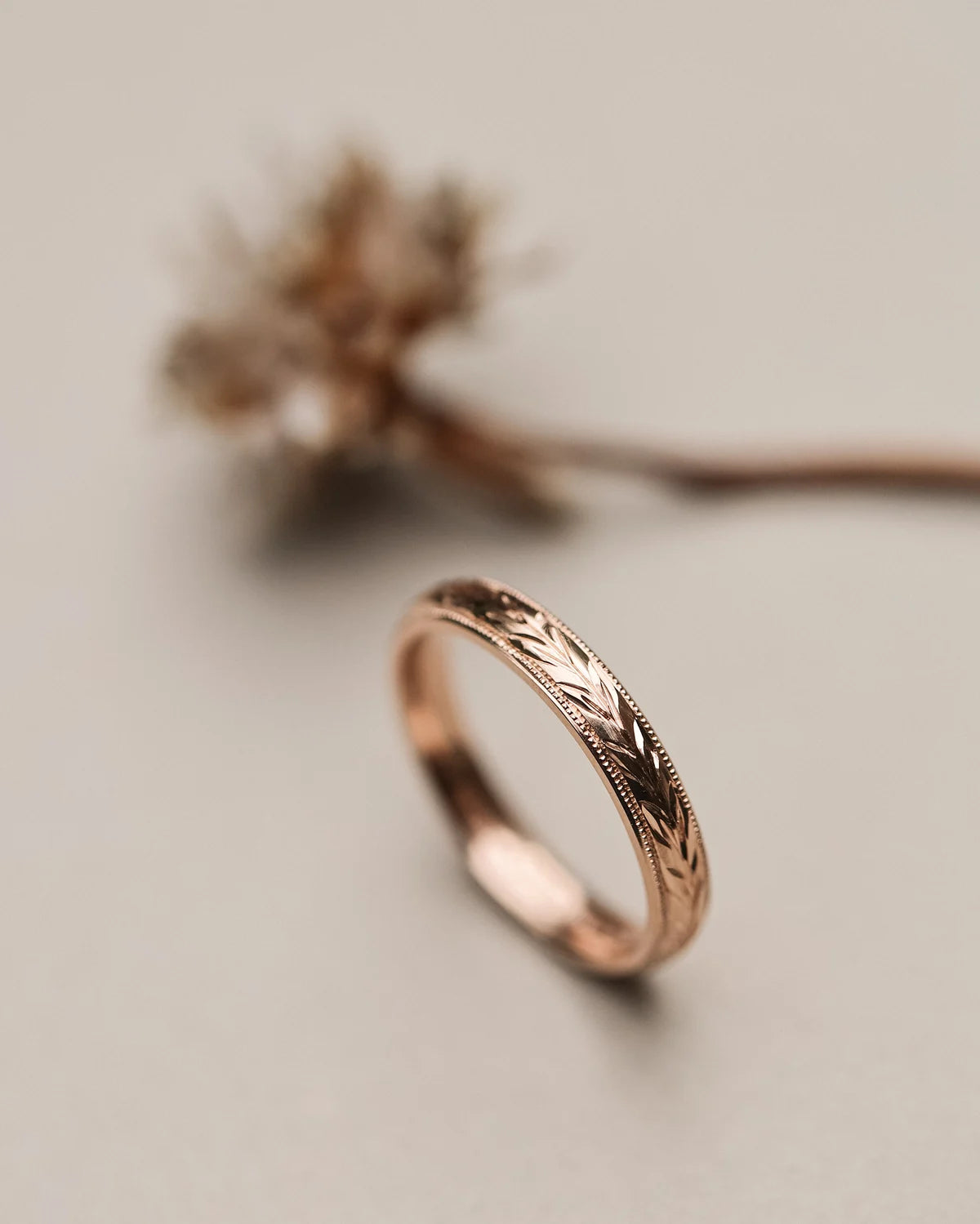 Side view of 18ct rose gold ring with hand engraved olive leaf motif