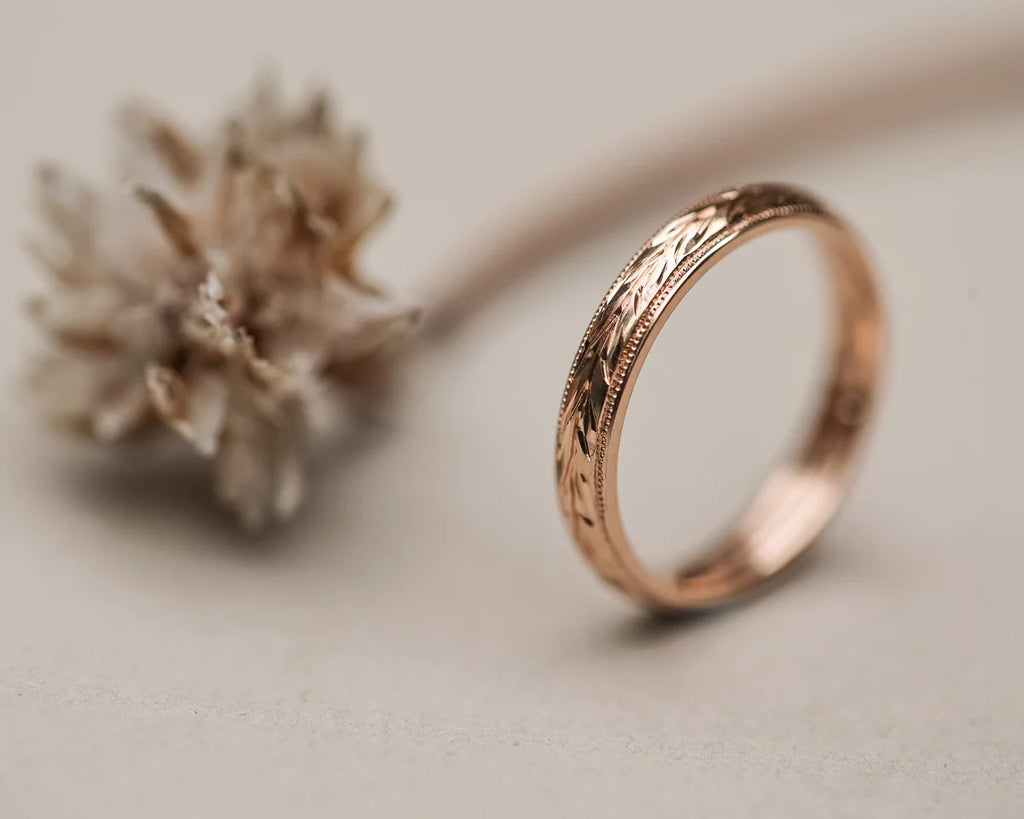 Detailed view of olive leaf engraving on 18ct rose gold band