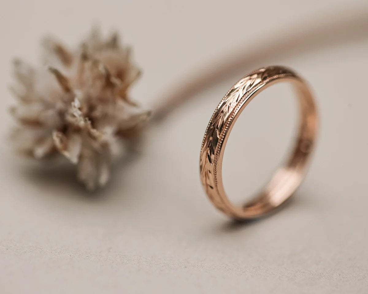 Detailed view of olive leaf engraving on 18ct rose gold band