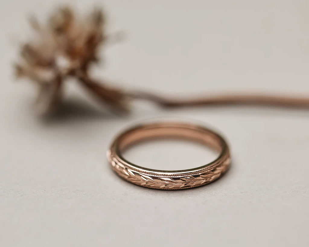 Low front view of 3mm rose gold olive leaf and milled edge ring