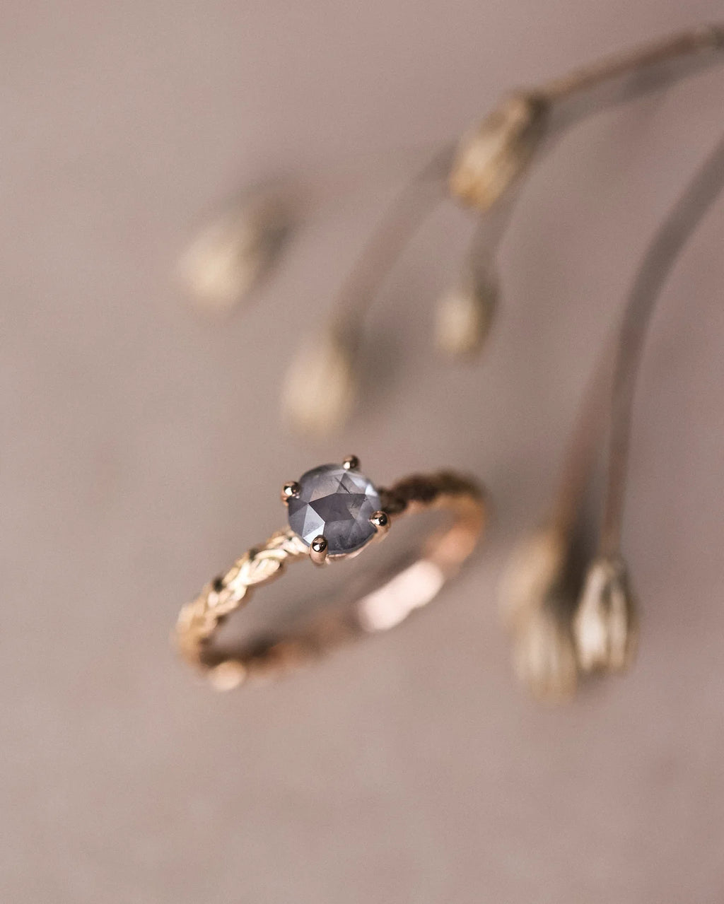 Soft focus close-up of grey rose-cut diamond and carved laurel band