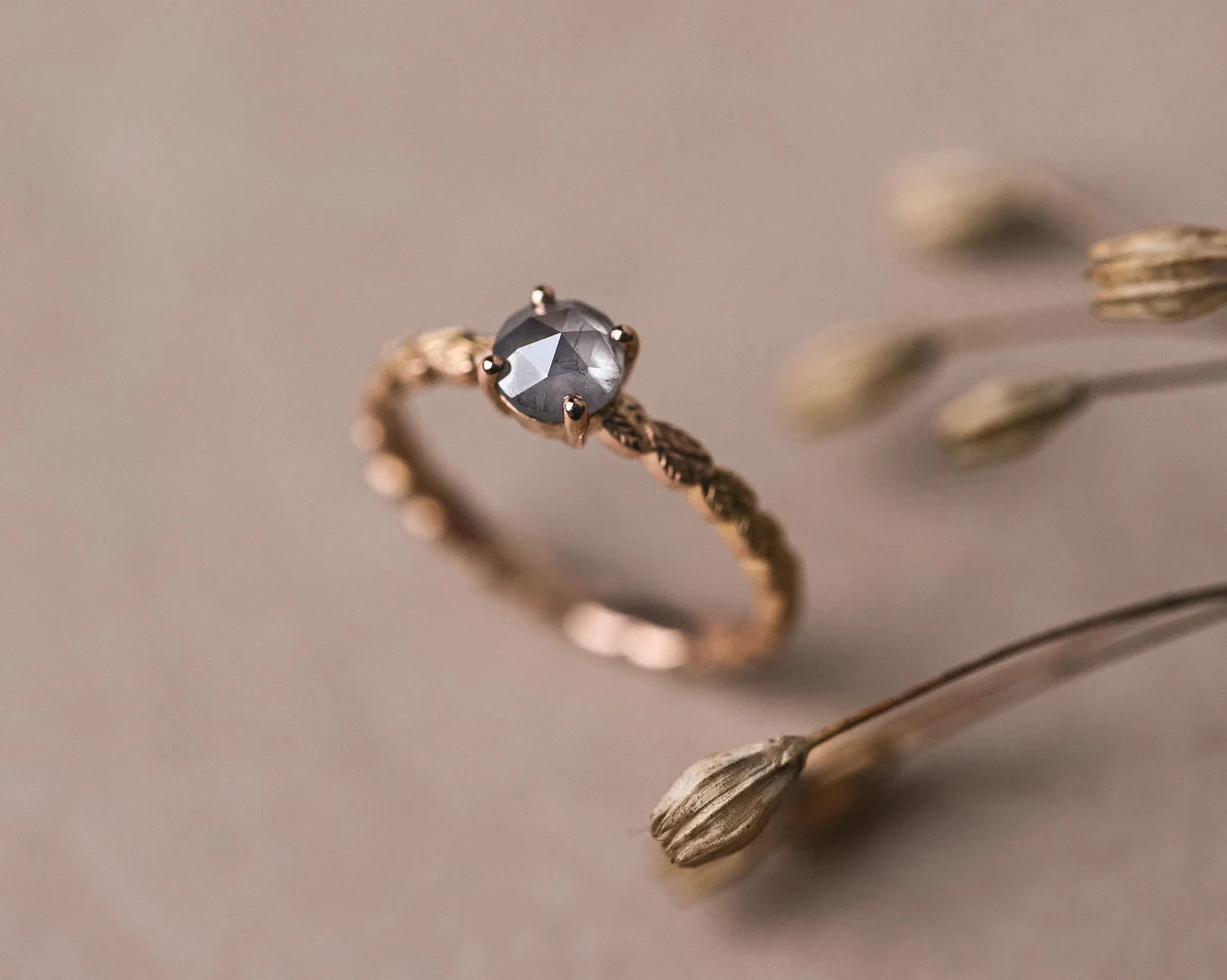 Angled view of 18ct rose gold laurel leaf ring with pale grey rose-cut diamond