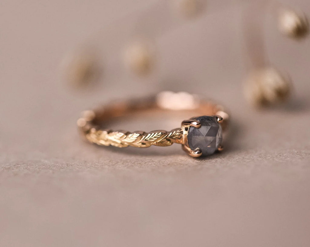 Close-up of natural pale grey rose-cut diamond on carved rose gold band