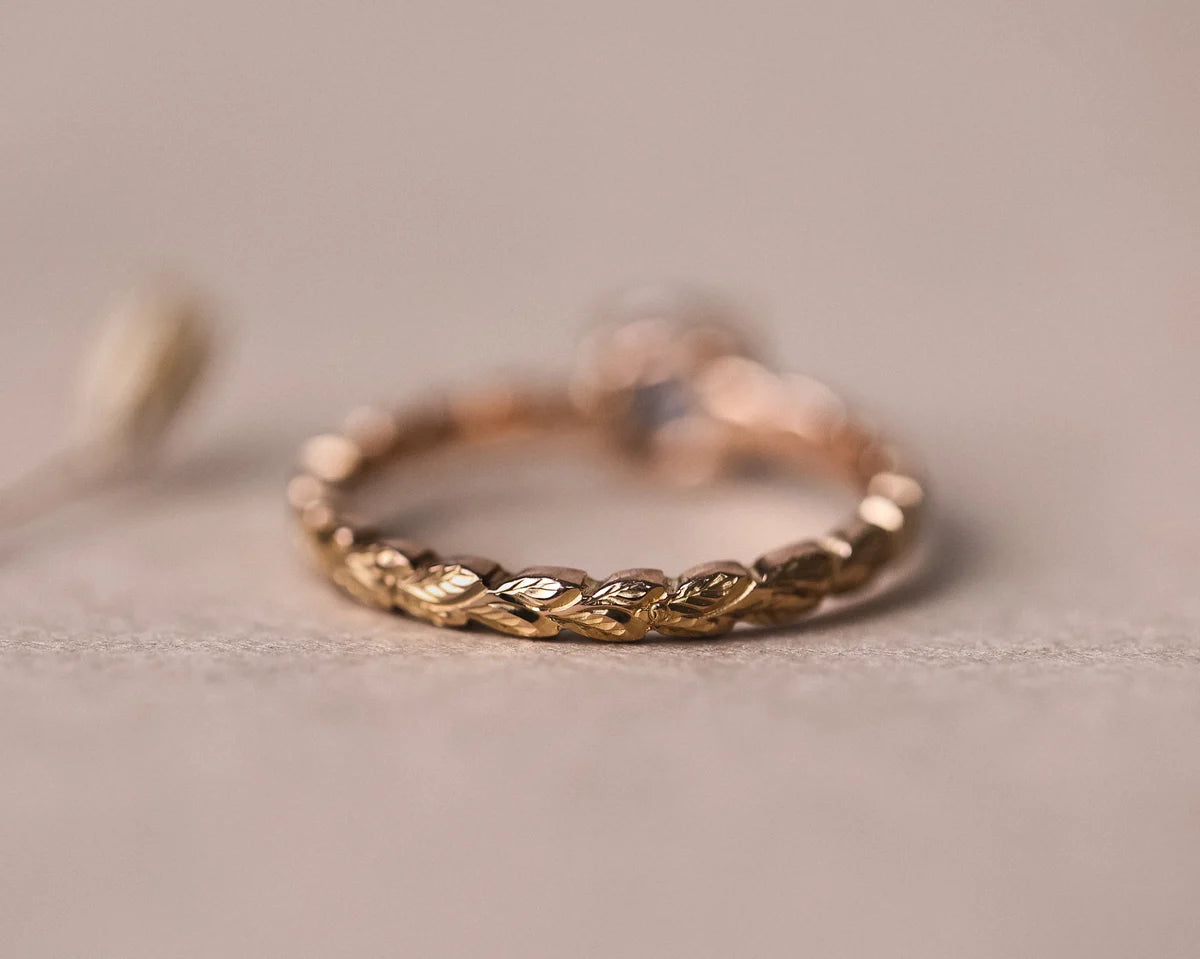 Back view of rose gold laurel leaf carved band with grey diamond setting
