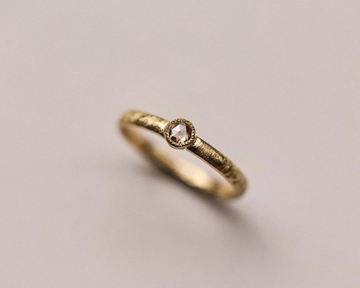 Angled close-up of handmade horn texture ring in 18ct yellow gold