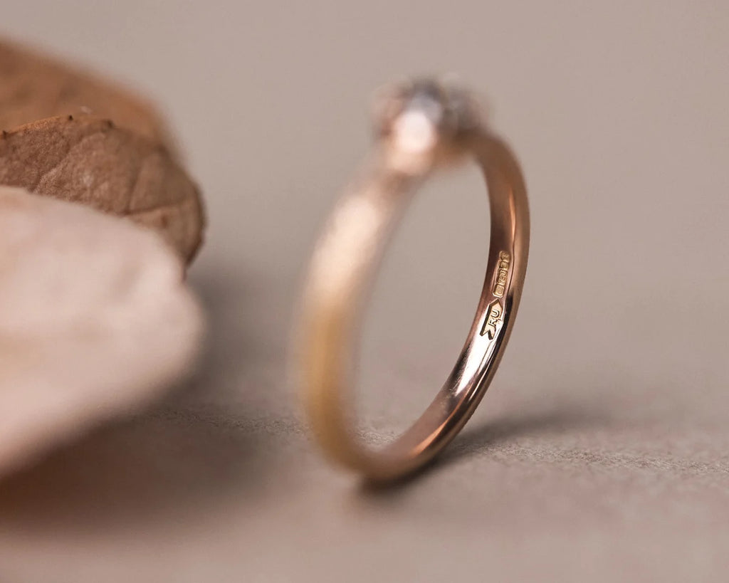 Side profile of laurel engraved rose gold ring with rose-cut diamond