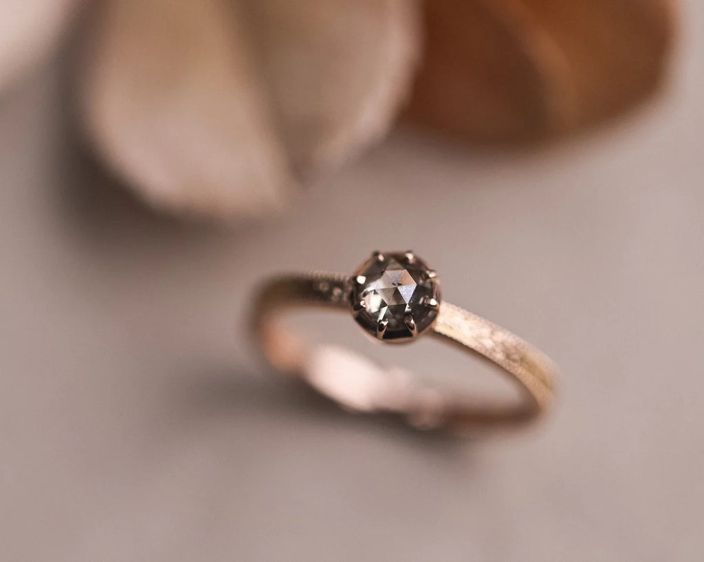 Angled view of 18ct rose gold laurel ring with brown-grey diamond