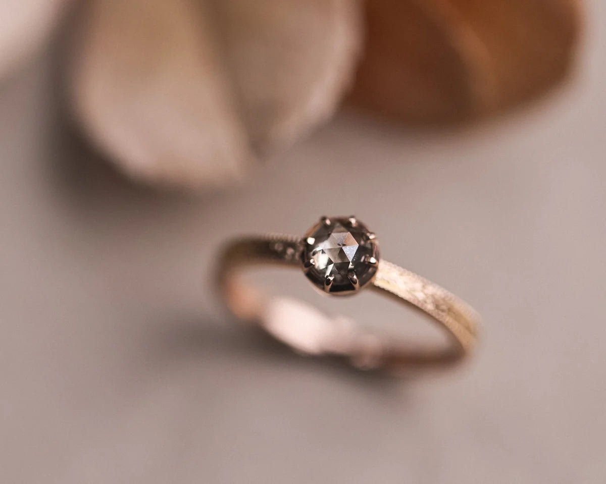 Angled view of 18ct rose gold laurel ring with brown-grey diamond