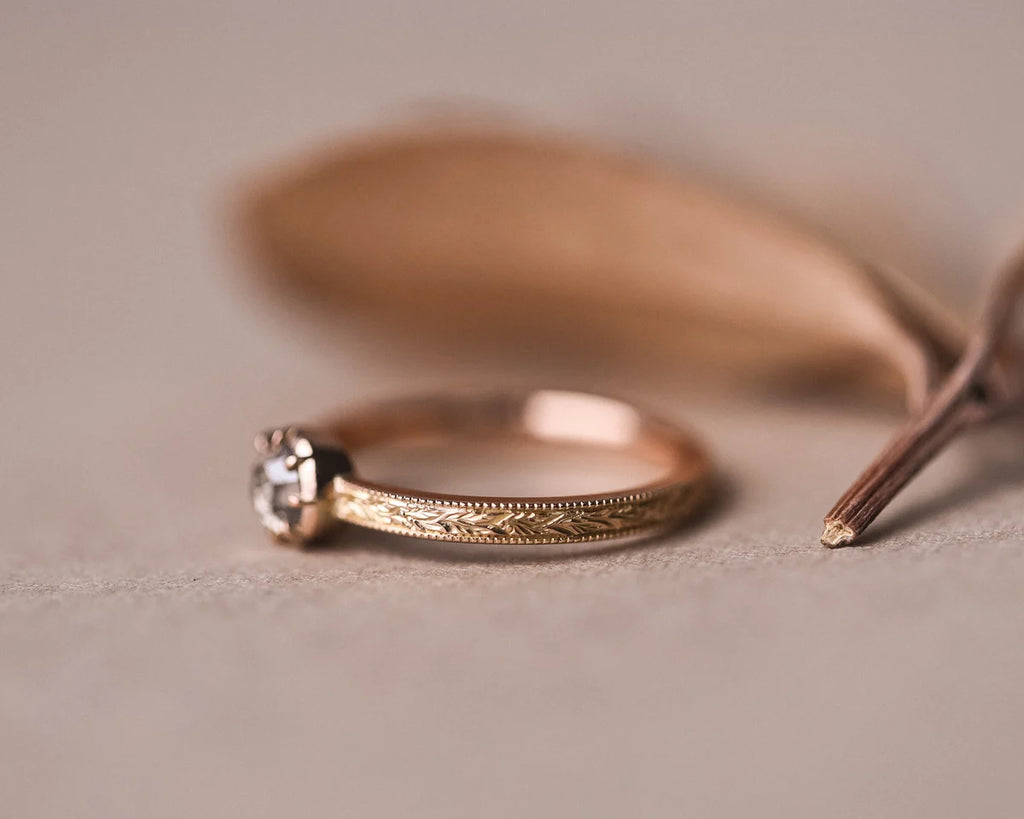 Close-up of brown-grey rose-cut diamond ring with milled edge detail
