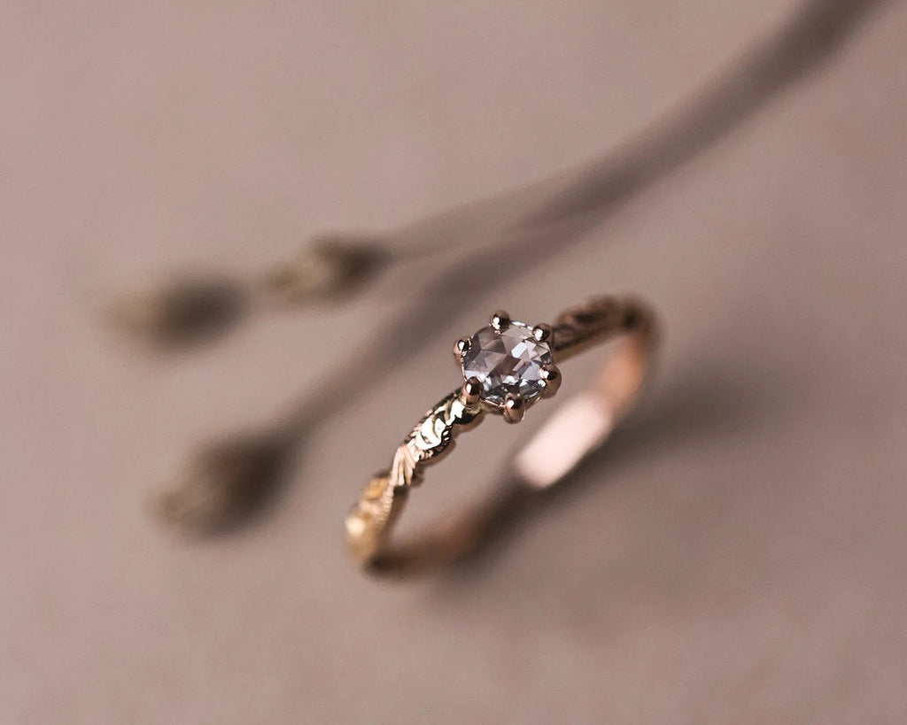 Angled view of handmade rose gold ring with rose-cut white diamond