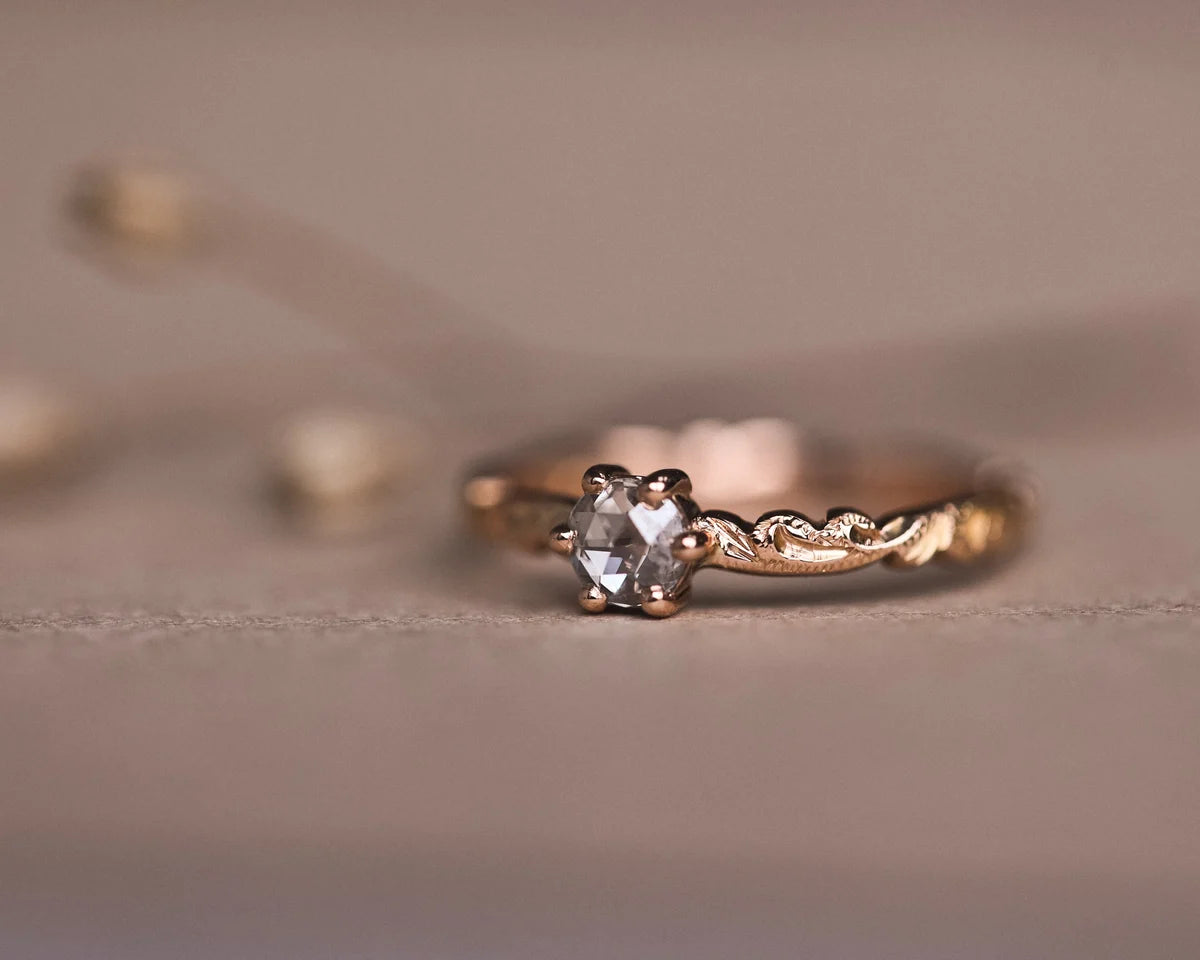 Low front view of rose-cut diamond ring with floral carved band
