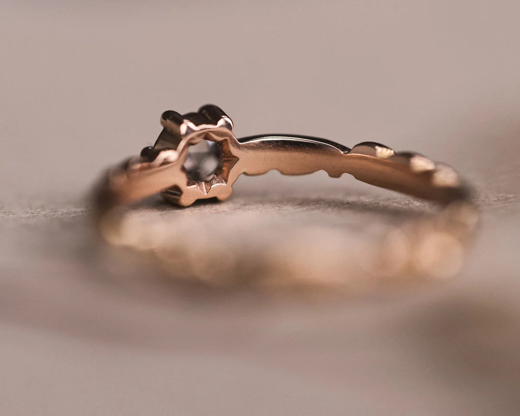 Rear profile of rose gold ring showing diamond setting and carved band
