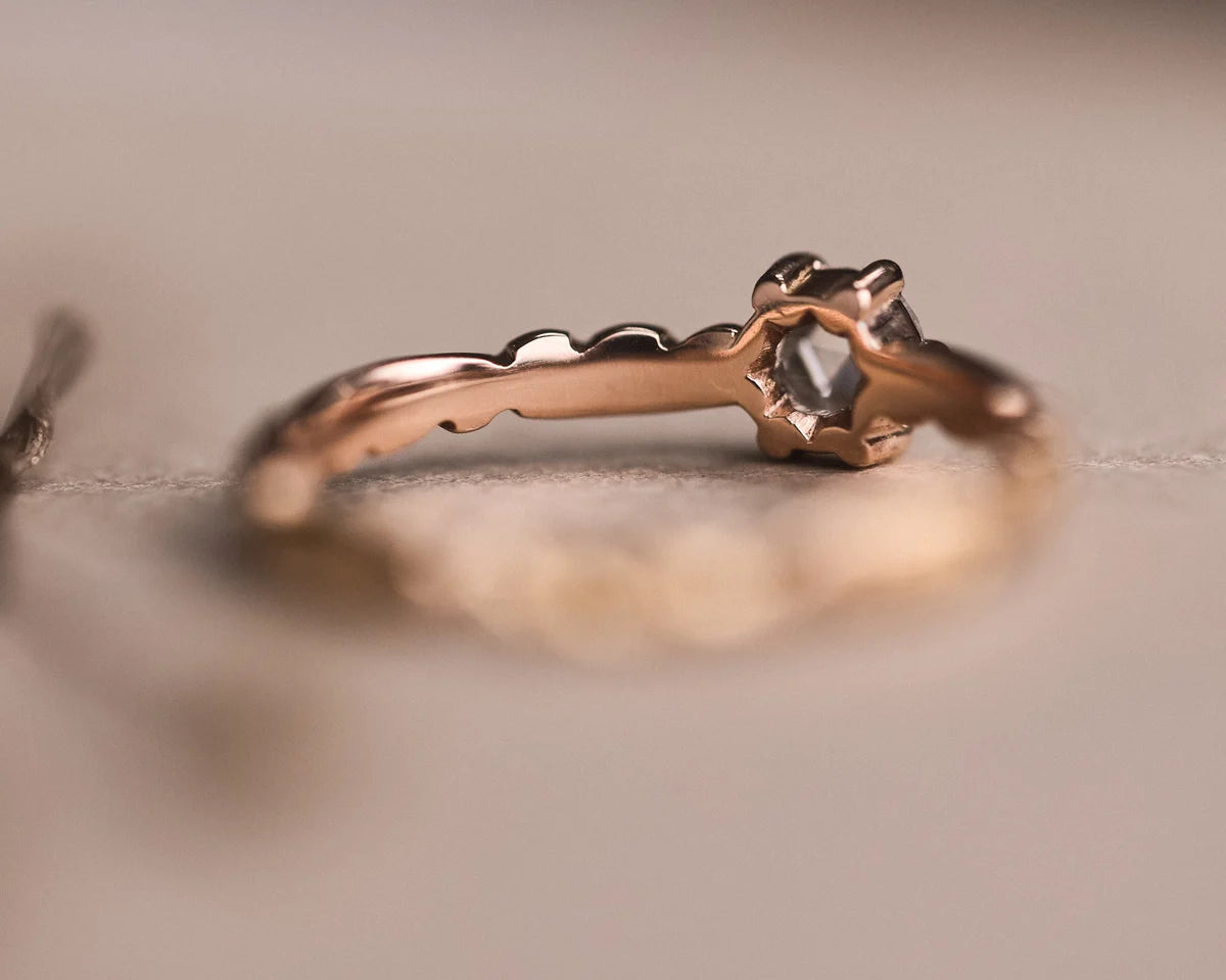 Side profile of rose-cut diamond ring showing carved floral band