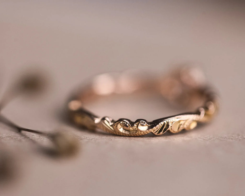 Close-up of hand carved floral band in 18ct rose gold