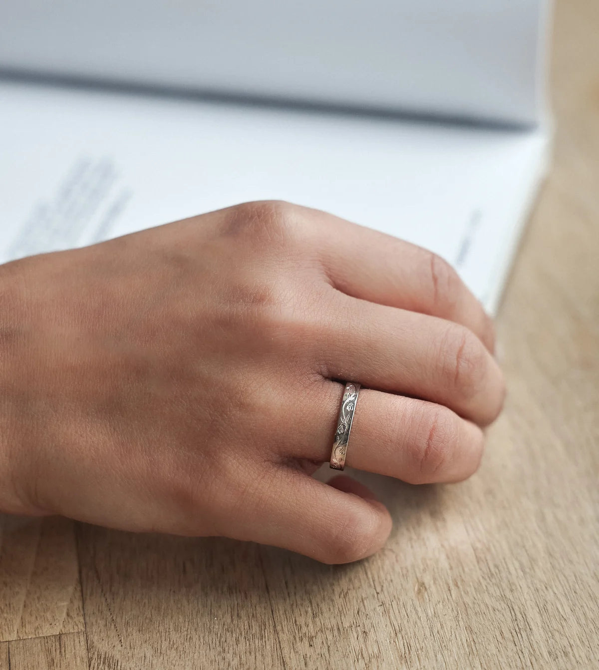Platinum snowdrop wedding ring worn on hand while writing