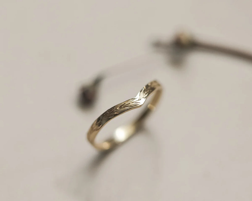 Angled close-up of 18ct yellow gold olive leaf wishbone wedding ring