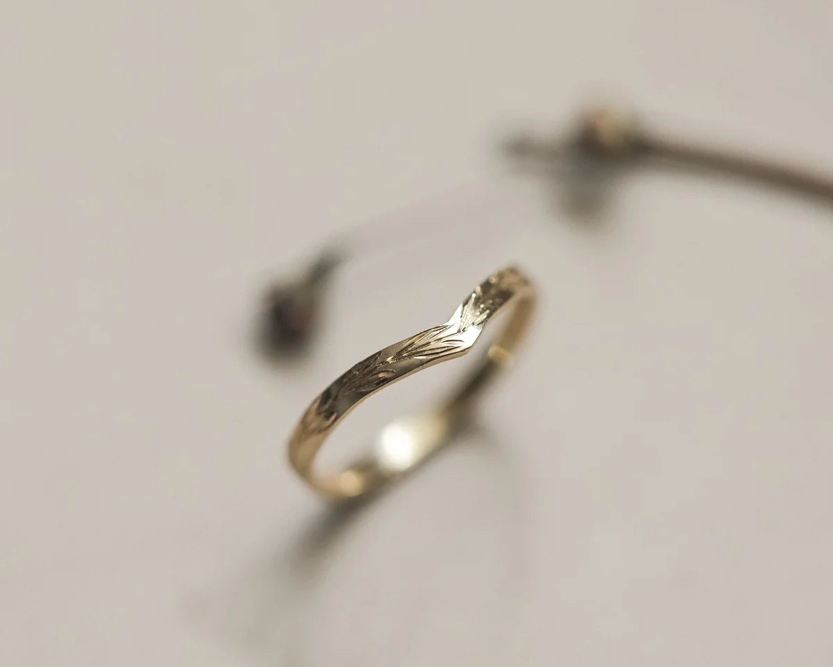 Angled close-up of 18ct yellow gold olive leaf wishbone wedding ring