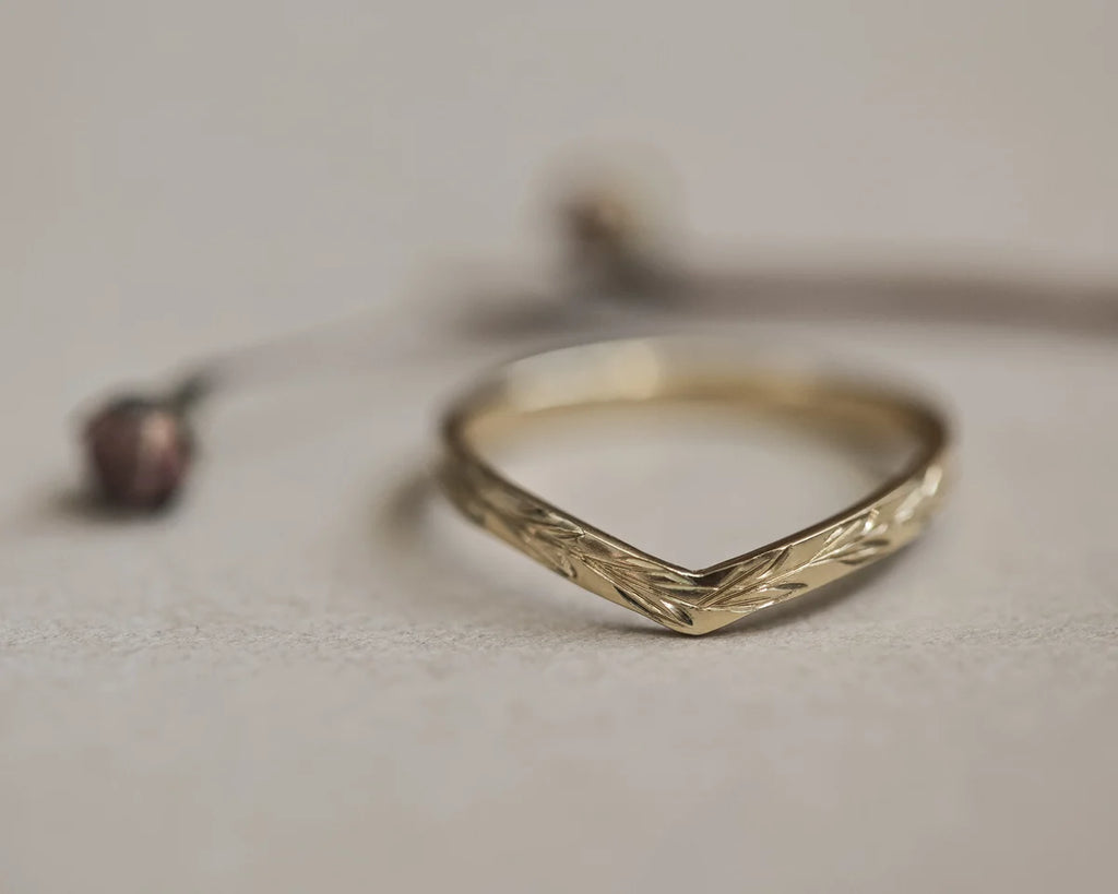 Front view of 2mm yellow gold wishbone ring with olive leaf engraving