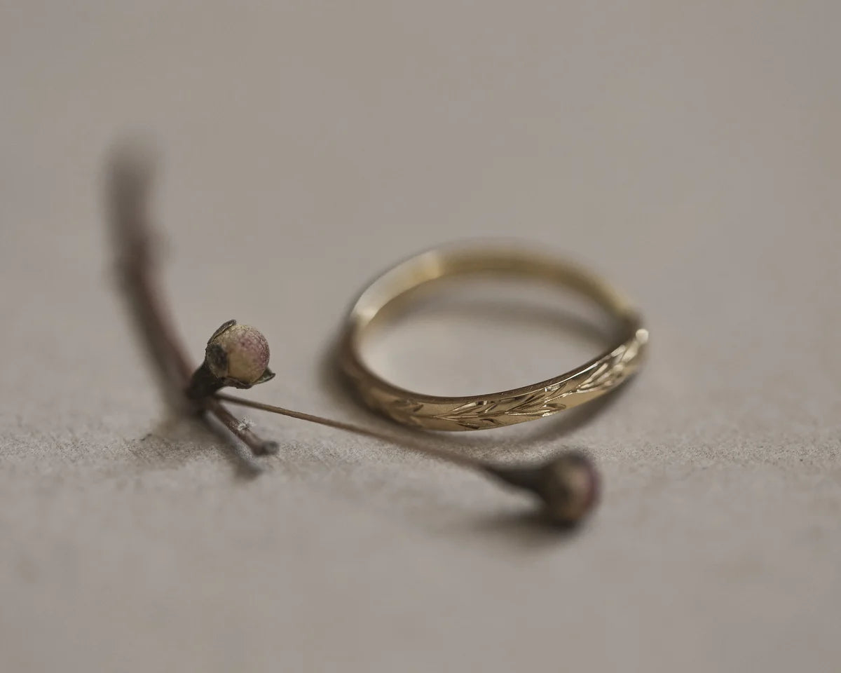 Side profile of handmade olive leaf engraved wishbone ring