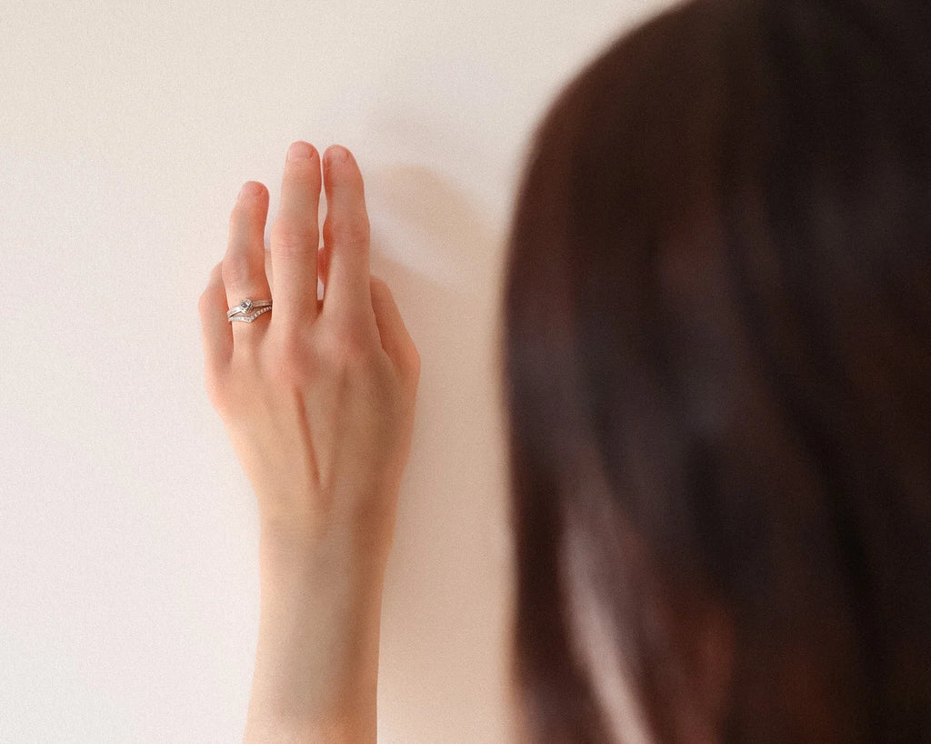 Woman wearing a handmade platinum rose-cut diamond engagement ring with matching wishbone band.