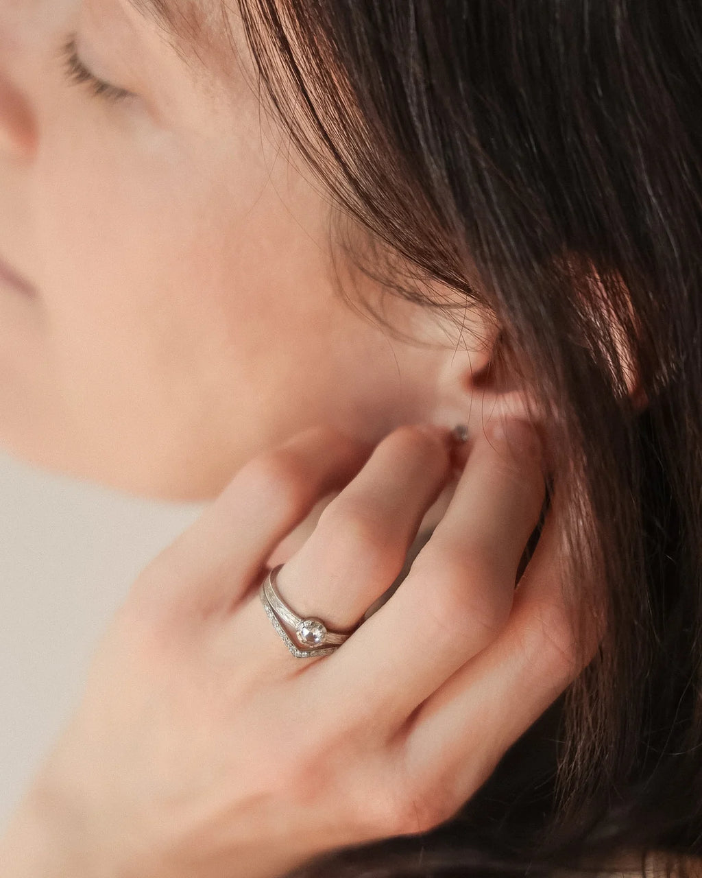 Delicate handmade platinum engagement ring worn on hand