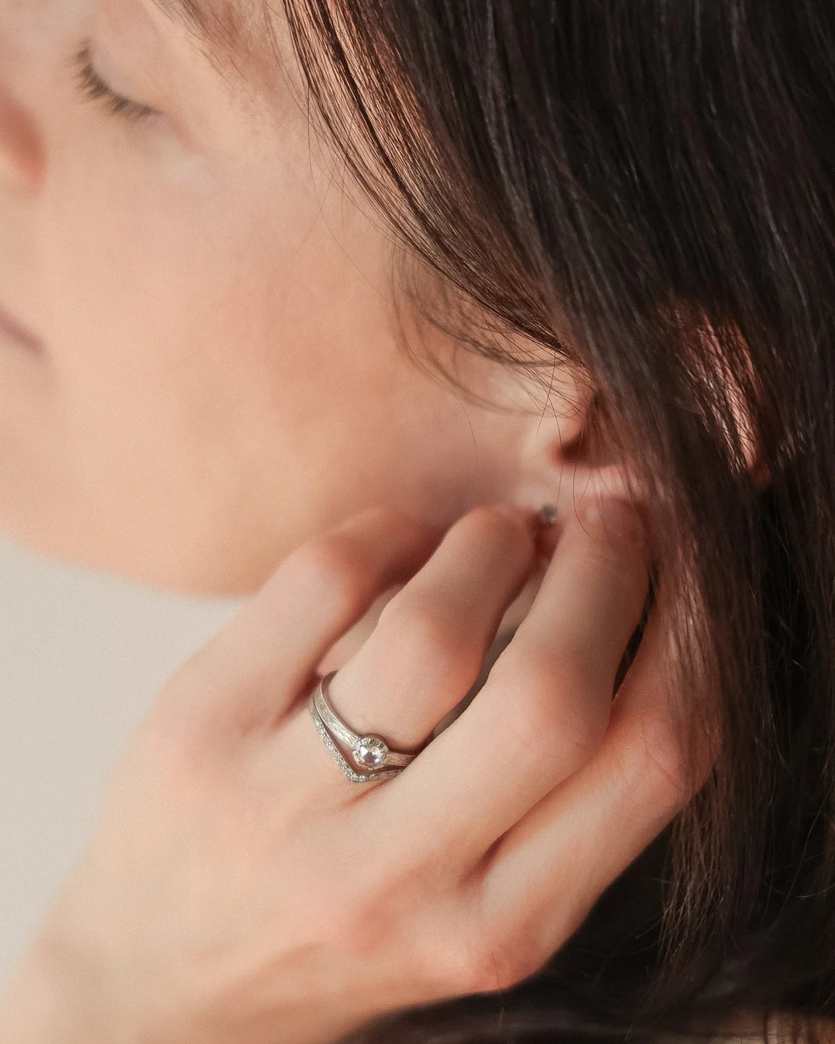 Delicate handmade platinum engagement ring worn on hand