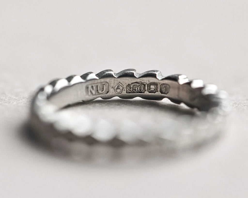 Silver ring with engraved text on a light gray background