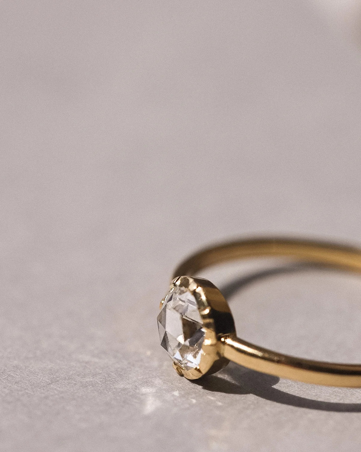 Profile view of rose-cut diamond solitaire ring in 18ct yellow gold
