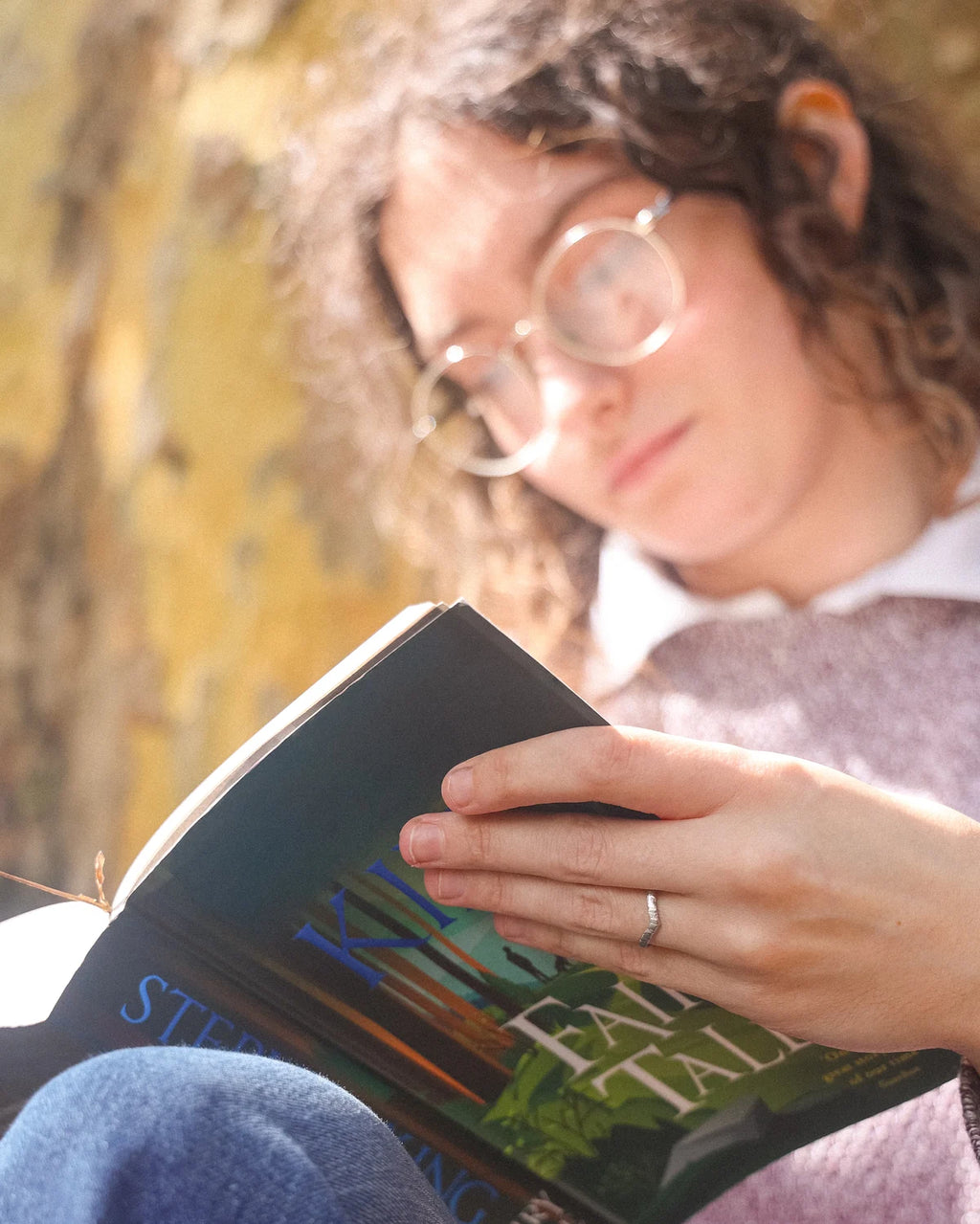 Horn texture platinum wishbone ring worn while reading book