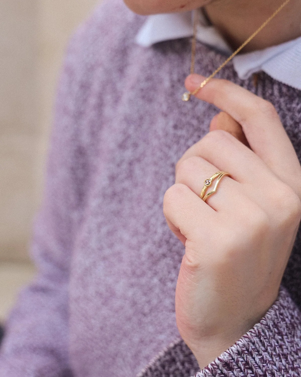 Champagne rose-cut diamond horn texture ring worn on hand with purple knit