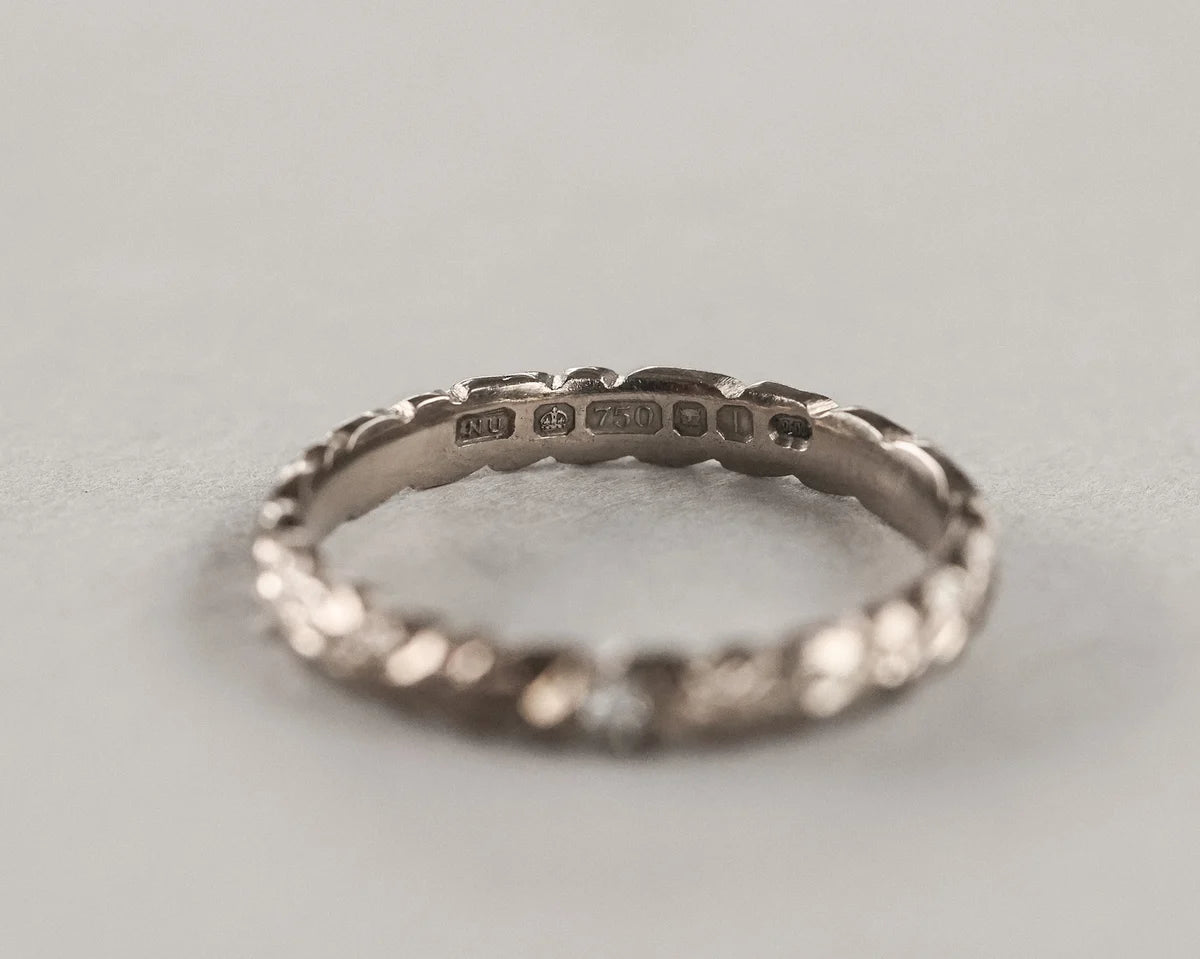 Silver ring with engraved details on a light gray background