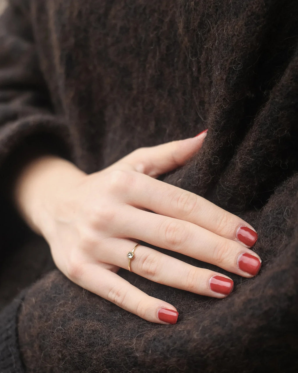 Yellow-grey rose-cut diamond ring worn on hand with dark knit styling