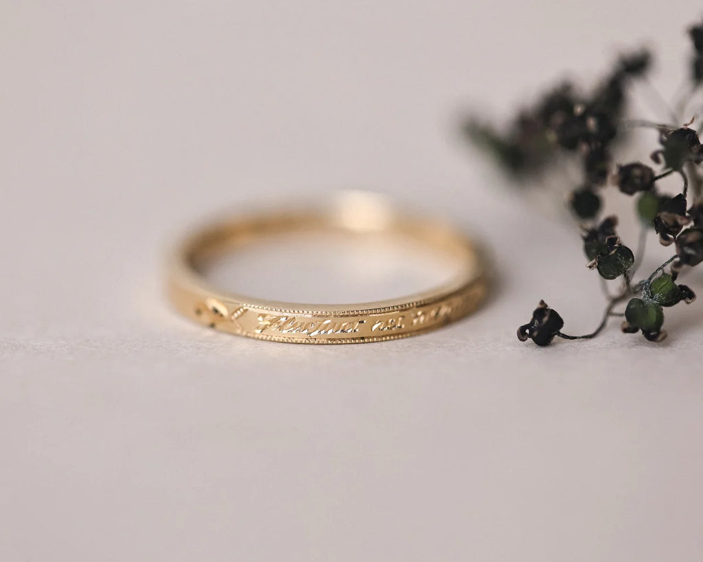 latin message engraved on gold wedding ring
