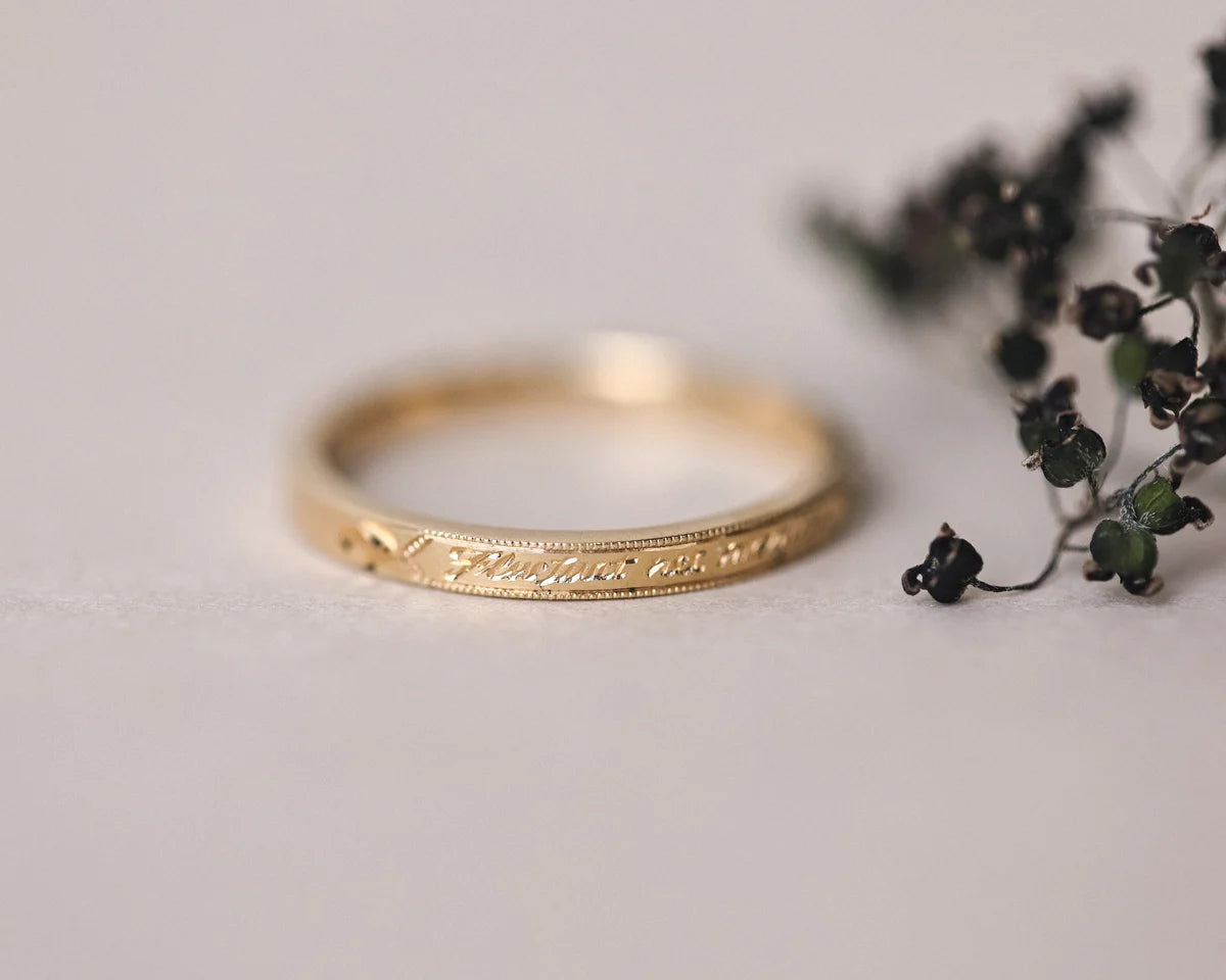 latin message engraved on gold wedding ring