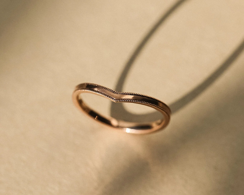 Angled side view of rose gold wishbone ring with polished interior