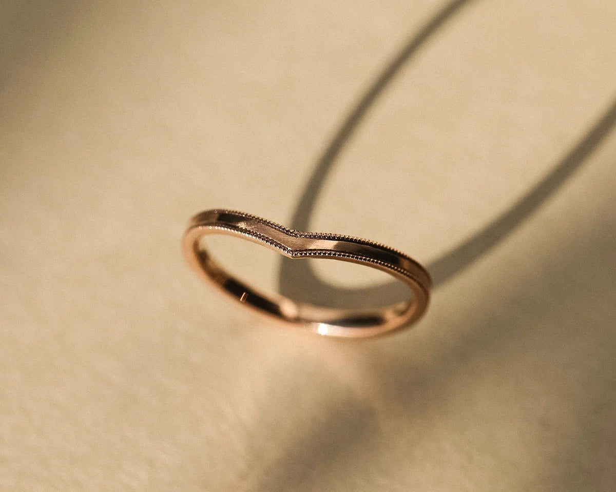 Angled side view of rose gold wishbone ring with polished interior