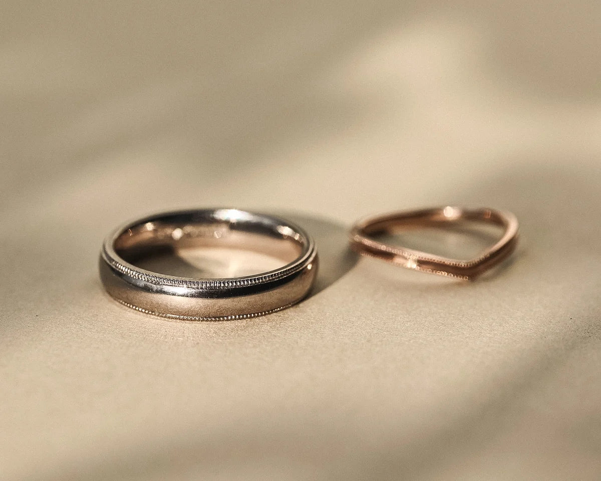 Handmade white gold wedding ring shown with rose gold wishbone ring