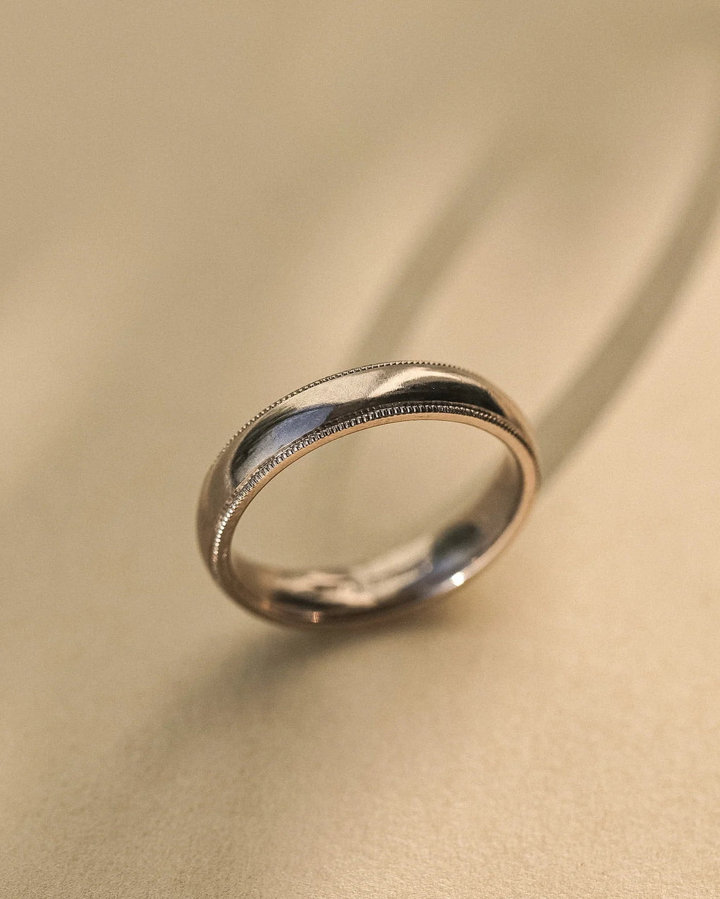 Angled view of handmade 18ct white gold court wedding ring